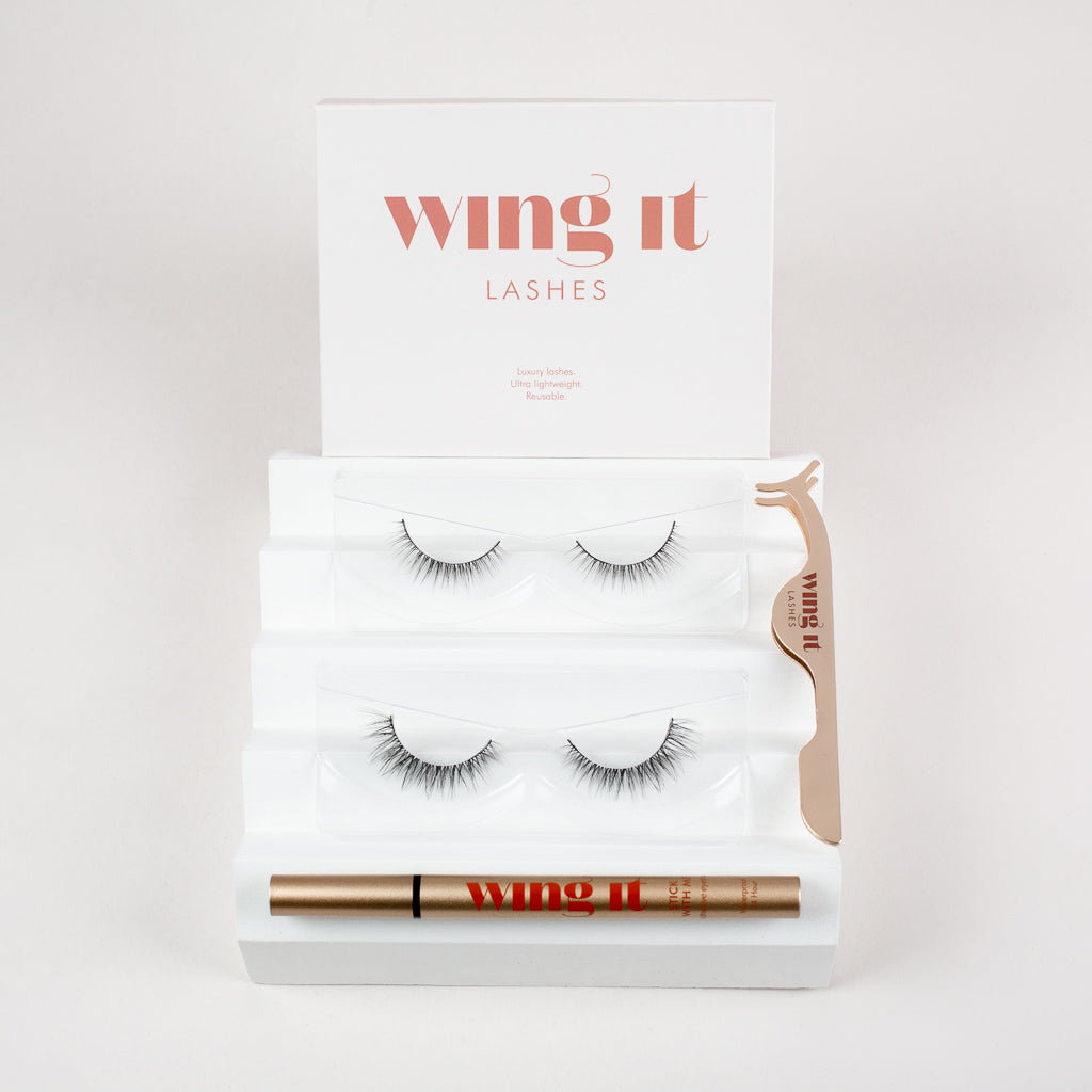 Set with two pairs of Wing It Cosmetics false eyelashes. Adhesive eyeliner. Golden lash applicator.